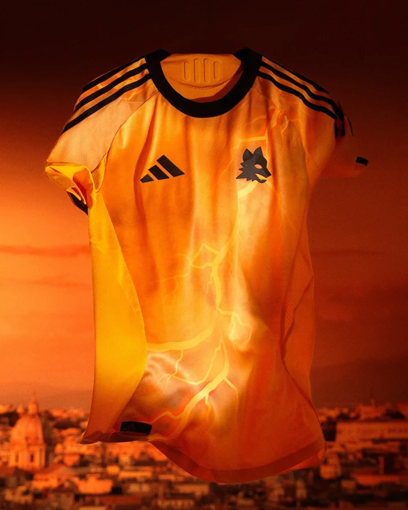 La camiseta visitante del AS Roma 2025-2026 es naranja y está atravesada por rayos
