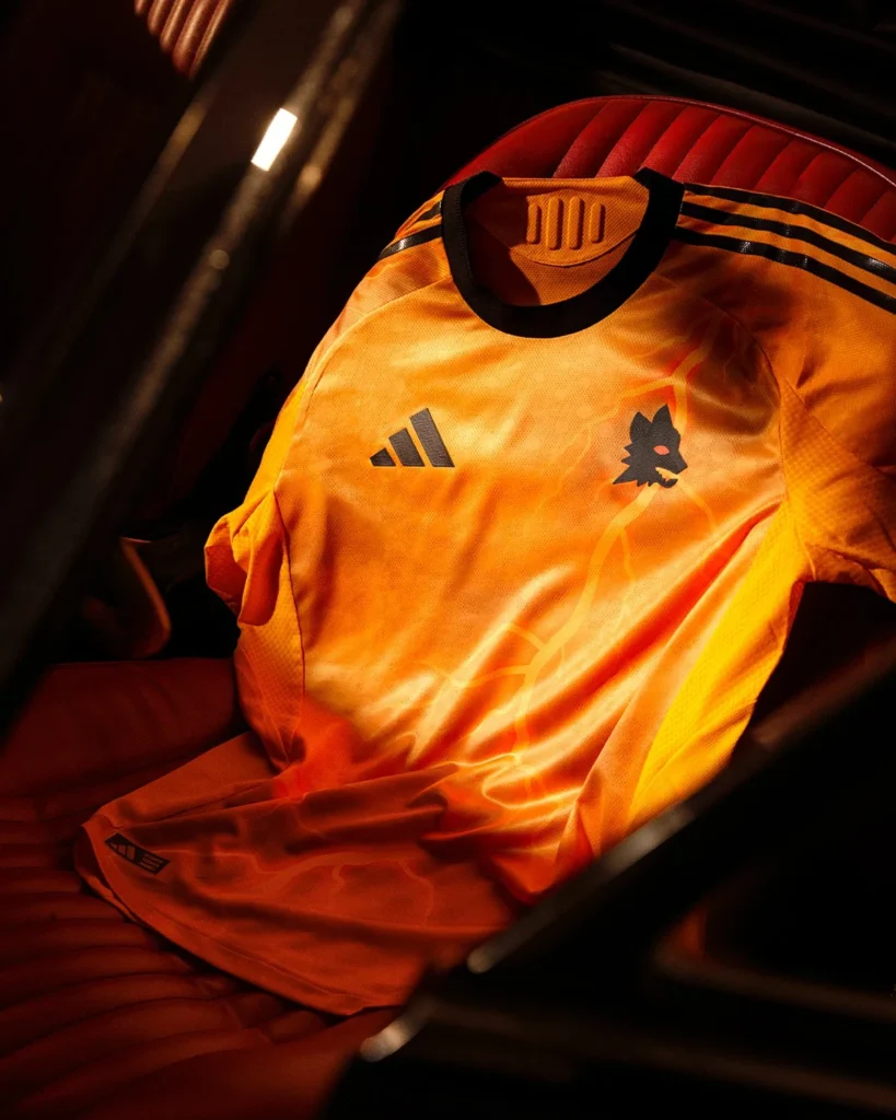 La camiseta visitante del AS Roma 2025-2026 es naranja y está atravesada por rayos