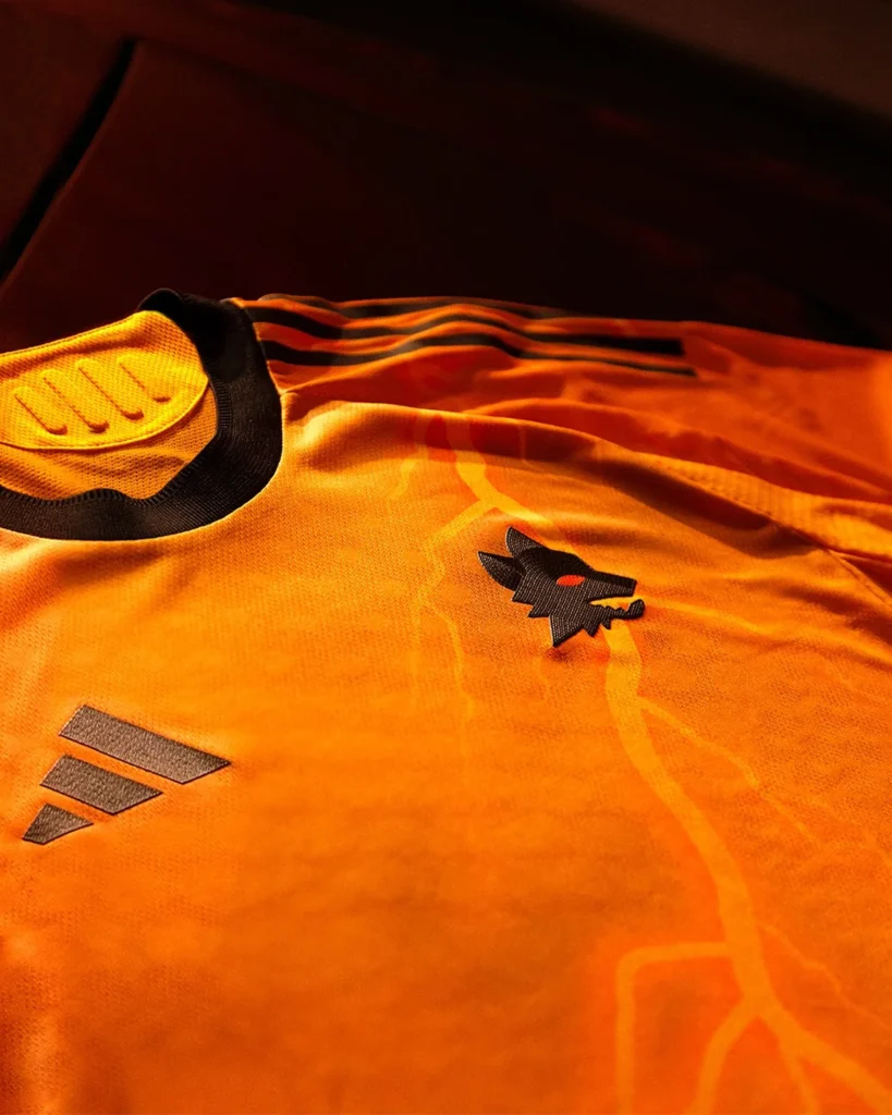 La camiseta visitante del AS Roma 2025-2026 es naranja y está atravesada por rayos